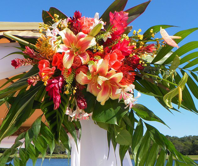 Vibrant tropical floral arrangement on outdoor arch