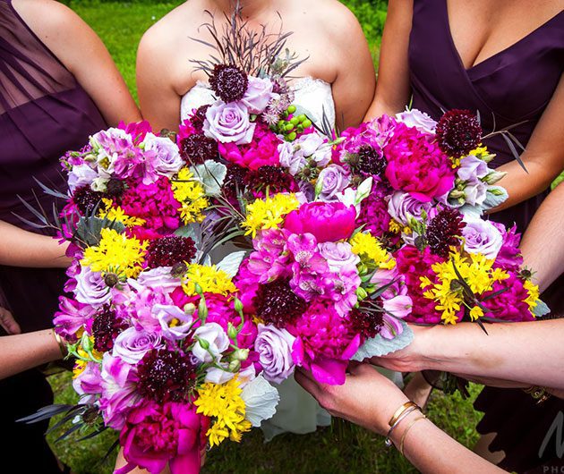 Bridal party holding vibrant pink and yellow bouquets