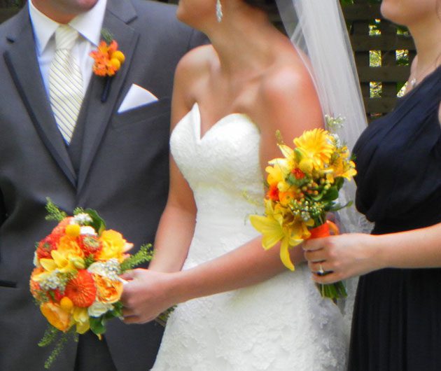 Bride in strapless gown holding yellow bouquets