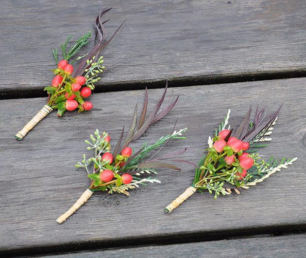 Three floral boutonnieres with red berries