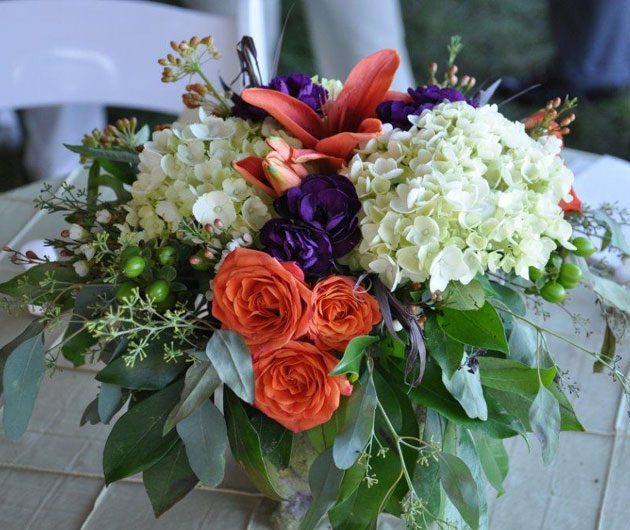 Vibrant floral centerpiece with orange roses, hydrangeas