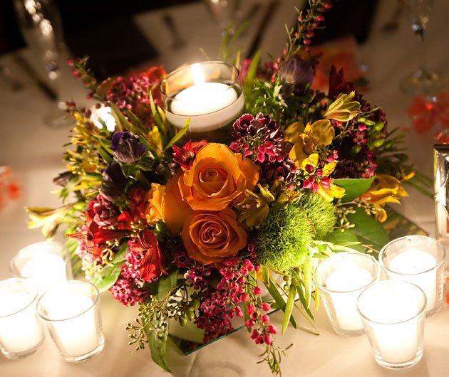 Candlelit floral centerpiece with orange roses