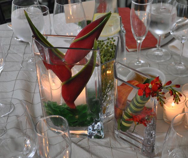 Dinner table centerpiece with red tropical flowers