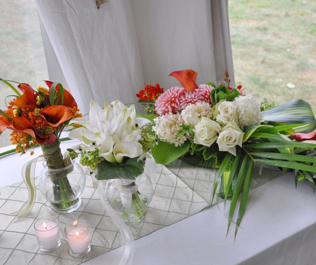 Mixed floral arrangements and candles on table