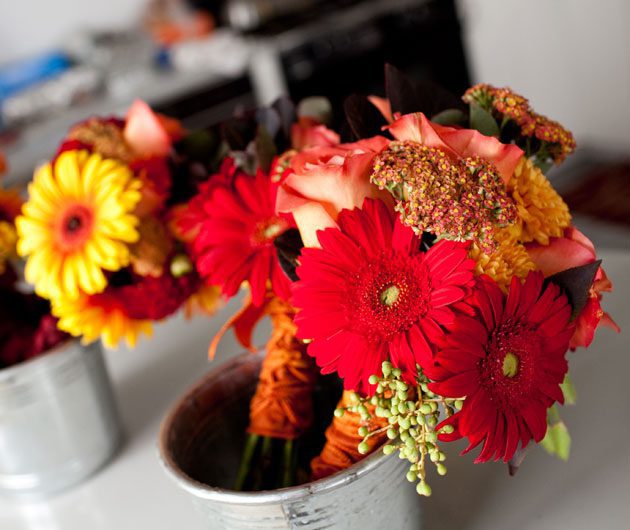 Red and yellow floral bouquet in metal bucket
