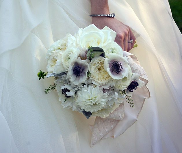 Bride holding white floral wedding bouquet