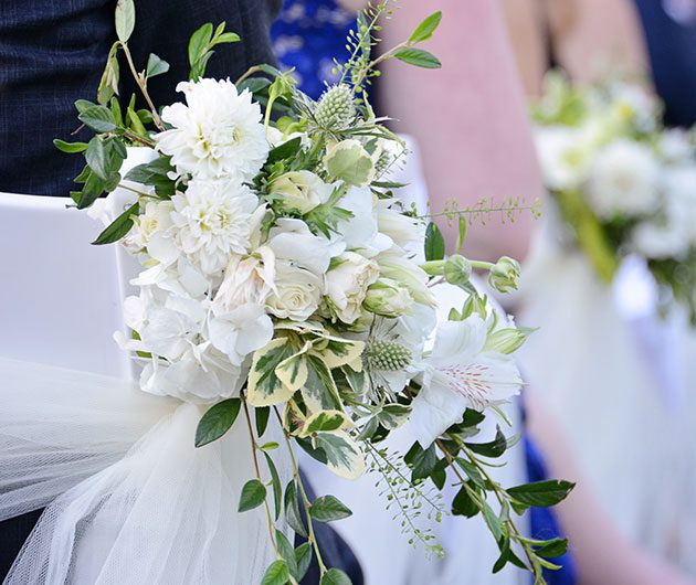 White wedding bouquet with greenery on chair