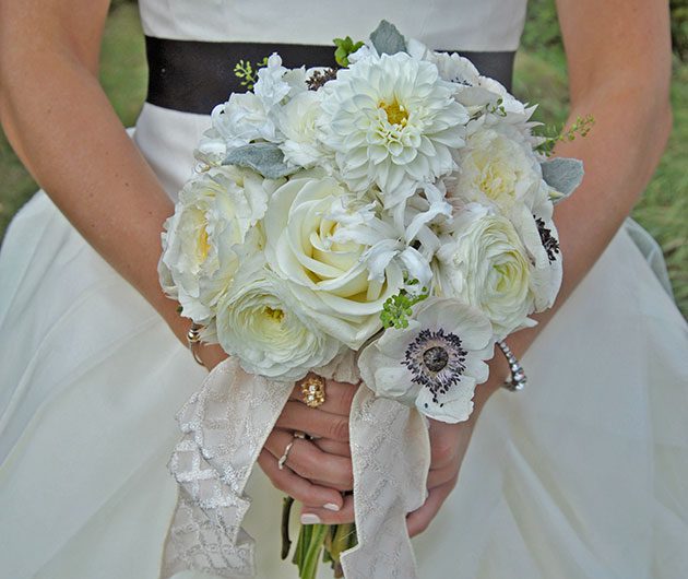 Bride holding white wedding bouquet with ribbon