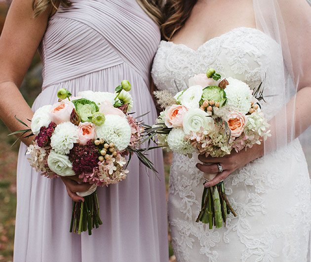 Bride and bridesmaid holding floral bouquets