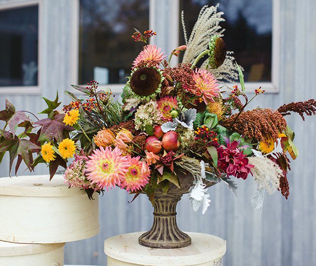 Autumn floral arrangement with apples in urn