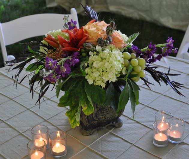 Colorful floral centerpiece with candles on table