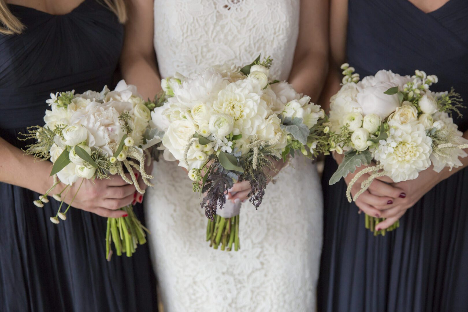 Bride and bridesmaids holding white bouquets