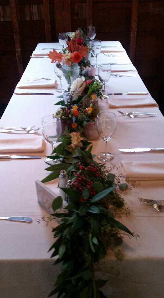 Long dining table with leafy centerpiece