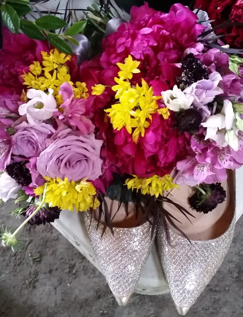 Sparkly shoes beneath vibrant mixed flower bouquet