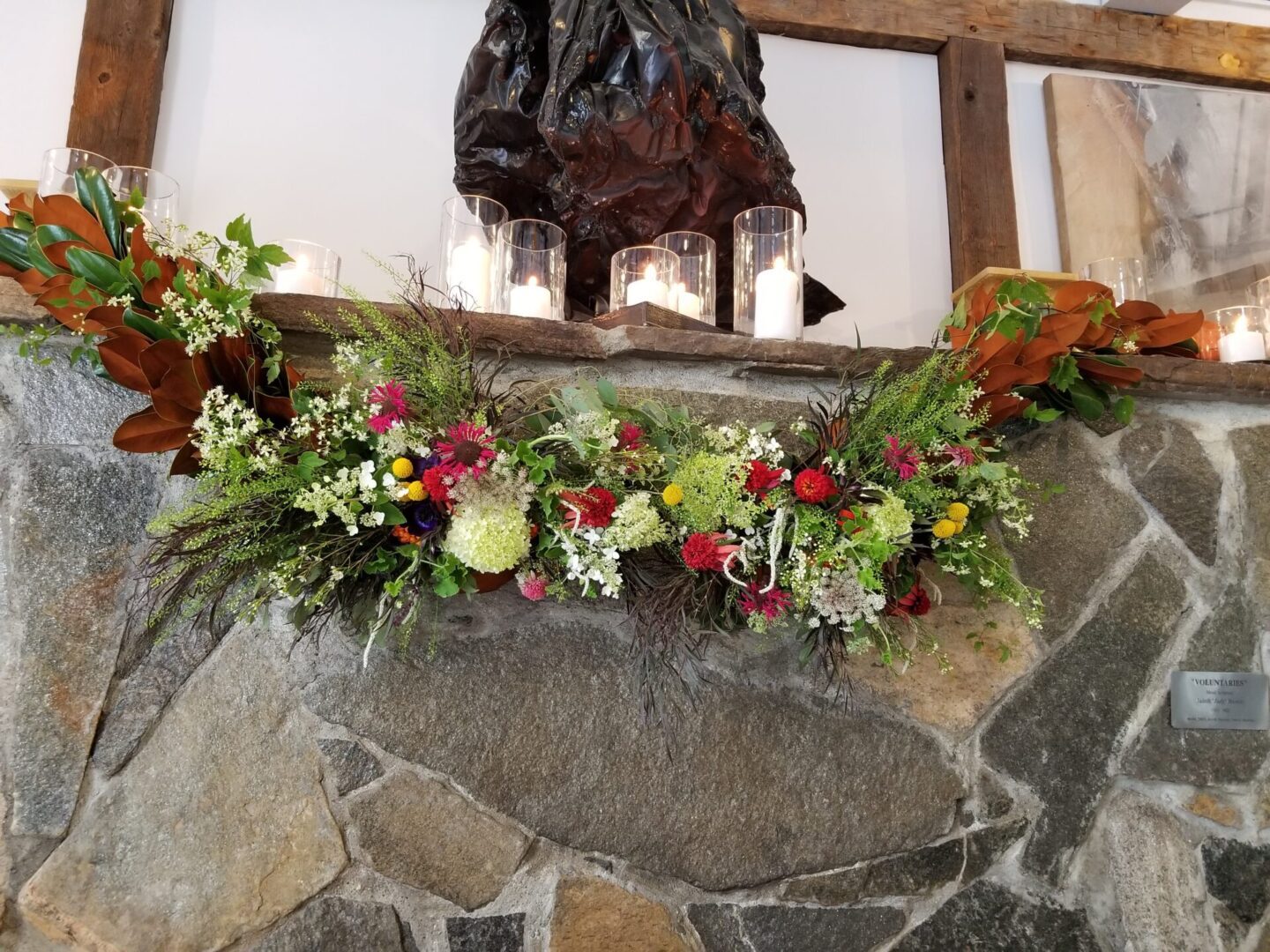 Rustic stone mantel with floral garland and candles