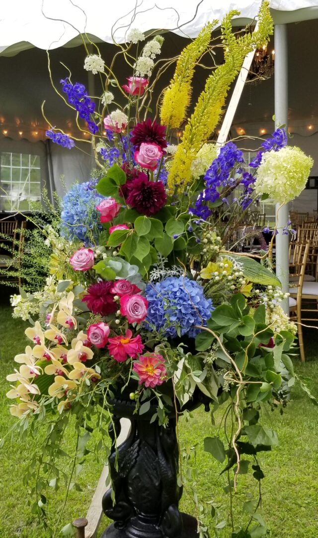 Tall vibrant floral arrangement in black vase