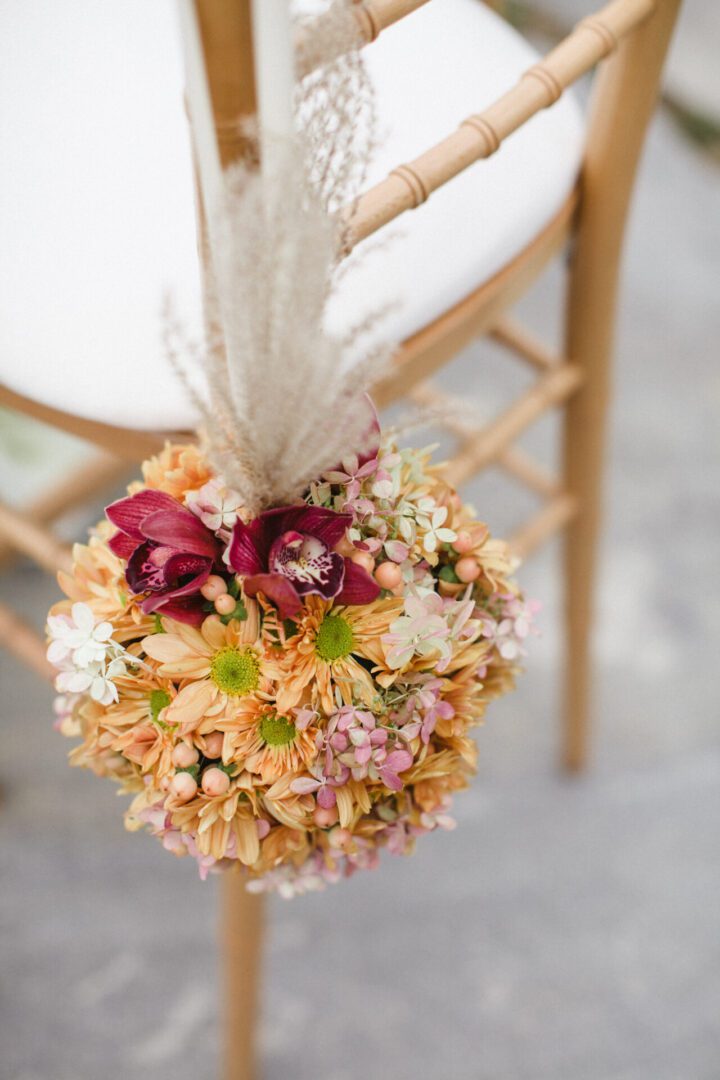 Peach floral pomander hanging from wooden chair